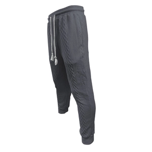 Close-up of charcoal grey knit joggers with cable knit patterns and drawstring waist
