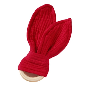 Organic wooden baby teether ring with red cotton rabbit ears on a clean white background
