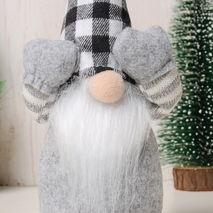 Close-up of faceless Christmas gnome with buffalo plaid hat and soft felt beard texture