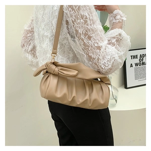 Detail of beige pleated cloud bag with soft PU leather texture and knotted strap design