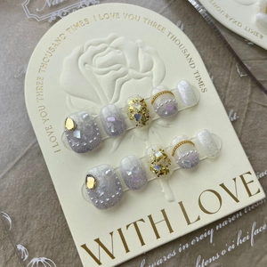 Detailed view of handmade purple glitter press-on nails with pearls and gold foil