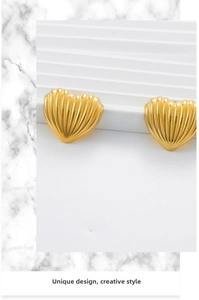 Detail of 18K gold heart earrings featuring unique vertical pleated texture and polished finish