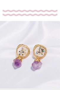 Detailed macro view of purple crushed shell and natural stone on gold earring