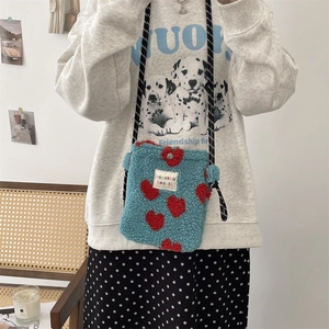 Détail du petit sac peluche bleu avec motif cœur rouge et bandoulière à pois