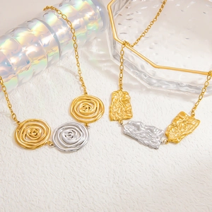 Detail of gold and silver mixed tone stainless steel necklace with textured pendants