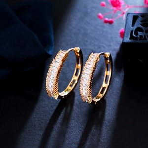 Minimalist gold hoop earrings featuring square baguette zircons in a channel setting