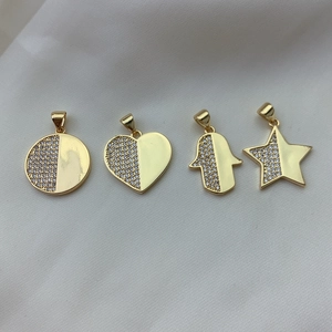 Detailed view of gold-plated charms with cubic zirconia in star, heart, and hamsa shapes