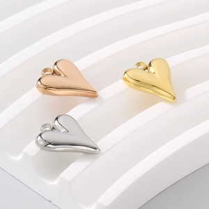 Polished heart pendants in gold, silver and rose gold on a white grooved display stand