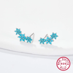 Macro shot of S925 sterling silver stud earrings with sky blue zircon flower clusters