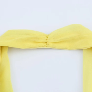 Detailed close-up of bright yellow fabric texture with elegant central knot craftsmanship