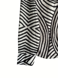 Detail shot showing the black and white geometric pattern and stitching on shirt cuffs