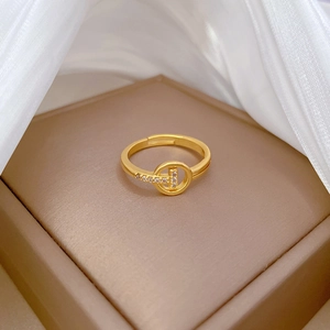 Adjustable gold T-letter ring with sparkling crystal inlay on a luxury display box