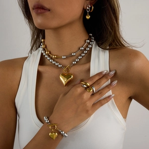Elegant two-tone stainless steel jewelry set featuring heart charms and beaded design