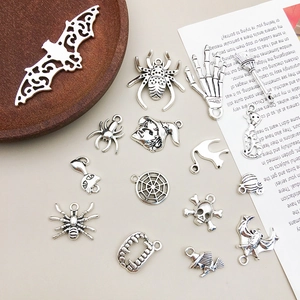 Close-up of vintage silver Halloween charms including spiders, bats and pumpkins for DIY