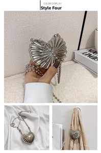 Close-up of heart-shaped silver metal mini bag with shell texture and bead chain