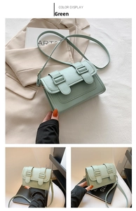Detail of mint green PU leather crossbody bag featuring vintage double buckle strap design