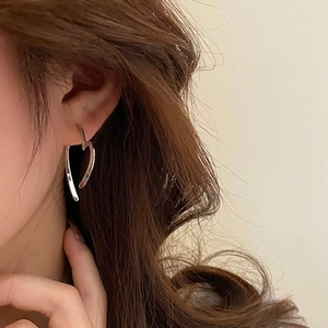 Nahaufnahme eines Models mit minimalistischem silbernem Herzohrring im modernen Stil