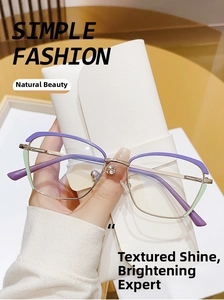 Detail of light gold cat-eye glasses frame with purple accents and green metal joints