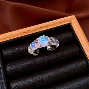Detailed macro view of three opalescent gemstones set in a silver vintage open ring
