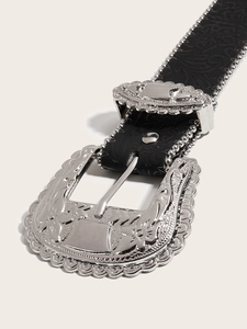 Detailed view of black leather belt with ornate silver western style floral buckle