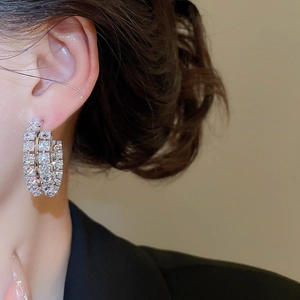 Gros plan de boucles d'oreilles créoles multicouches en zircon portées par un mannequin