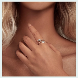 Nahaufnahme eines silbernen Blattrings am Finger mit feiner Metallstruktur und Design