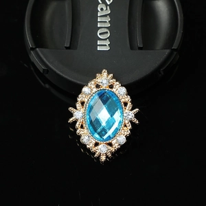 Detailed macro view of an oval blue gemstone pendant with a golden ornate frame