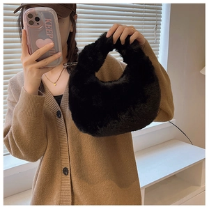 Detail of black fluffy faux fur handbag shown in a lifestyle mirror selfie context