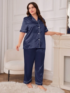 Detail of dark blue satin pajama set with contrast white piping and button-up front shirt