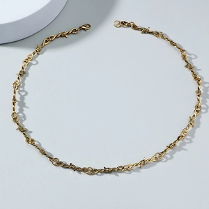 Detailed view of the gold-colored thorn necklace with a secure lobster clasp closure