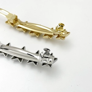 Macro shot of gold and silver star-shaped metal hair clips with polished finish
