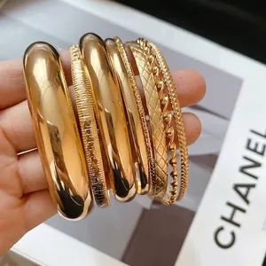 Ensemble de huit bracelets en métal doré au fini poli et aux motifs texturés variés