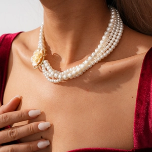 Dettaglio della collana di perle multistrato con fiore in resina e zirconi