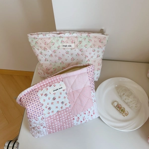Gros plan sur les trousses à maquillage en coton matelassé aux motifs floraux
