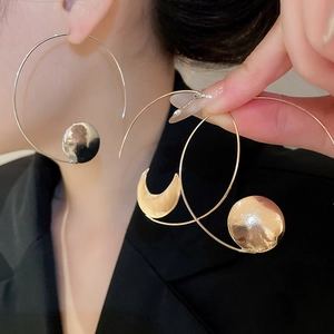 Detail showing the hammered texture of large geometric circle earrings with crescent charms