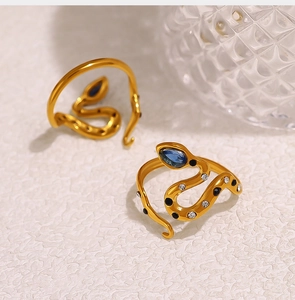 Detailed macro view of gold-plated snake ring with blue zircon eye and fine stone inlay