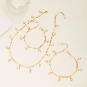 Detail of gold-tone heart pendant necklaces and bracelets with clear crystal inlays