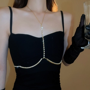 Dettaglio della lussuosa catena corpo dorata con strass e nappe a forma di Y indossata su modella