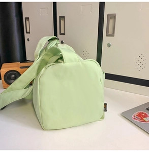 Sac de sport en nylon vert menthe au design matelassé exposé dans un bureau minimaliste