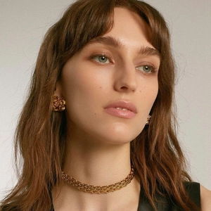 Golden rose stud earrings and chunky woven punk chain necklace set on female model