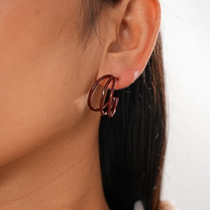 Close-up of deep red triple-line C-shaped hoop earring on ear with glossy finish