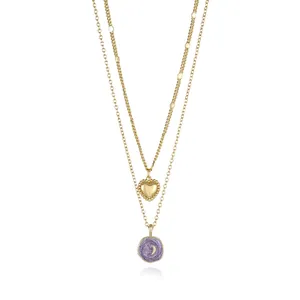 Close-up of double-layer gold necklace with heart and purple moon pendants