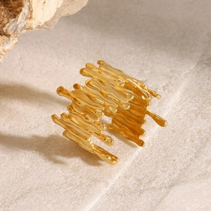 Macro shot of gold wide lava-style irregular ring on natural stone background
