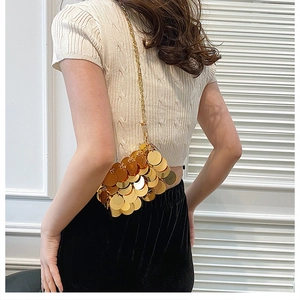 Detail of a women's gold metal sequin crossbody bag with a stylish chain strap