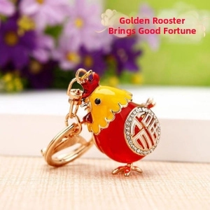 Detail of a gold chicken keychain with red enamel, crystal rhinestones, and Fu character