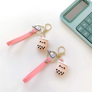 Close-up of pink milk tea cup keychains with wrist straps and golden clasps