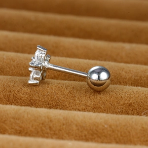 Floral stainless steel piercing earring with sparkling zircons on a brown tray