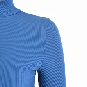 Detail of blue ribbed knit high collar top showing fabric texture and shoulder seams