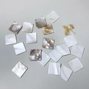 Detailed view of polished square natural white mother of pearl shell tiles for DIY jewelry