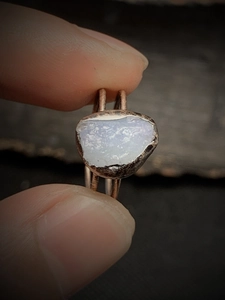 Macro shot of an adjustable vintage ring featuring an irregular purple raw stone and aged metal